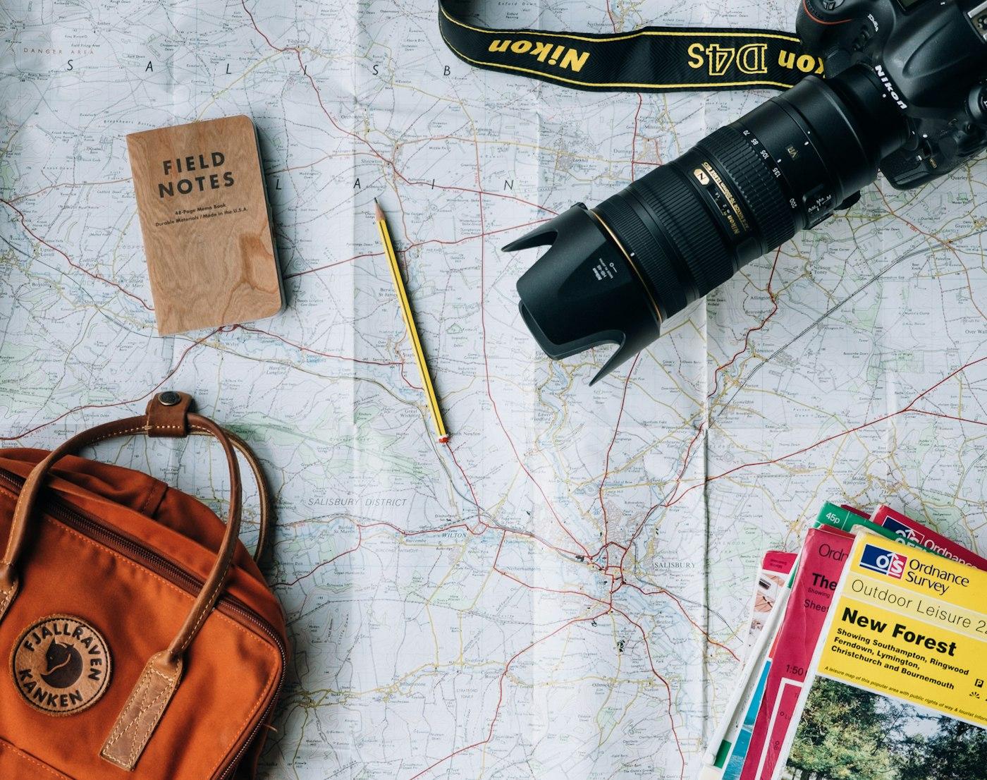 Mapa, câmera e mochila preparados para uma viagem